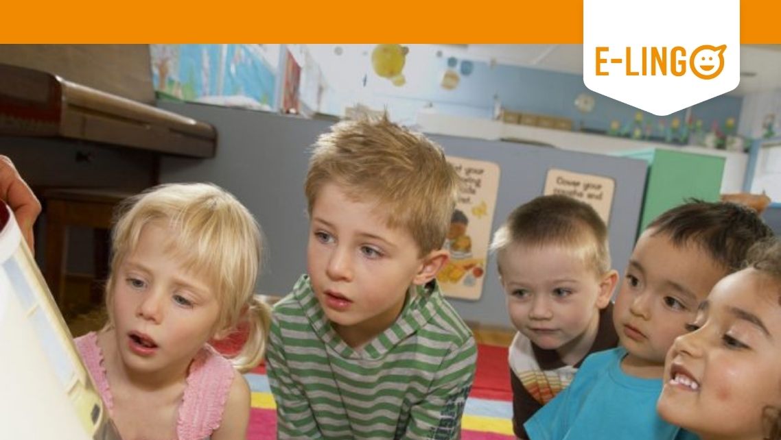 Five children curiously looking at a picturebook